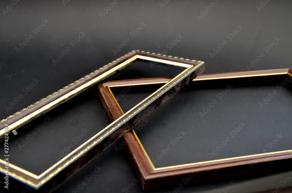 Wooden frame for photos and paintings on a black background with leaves