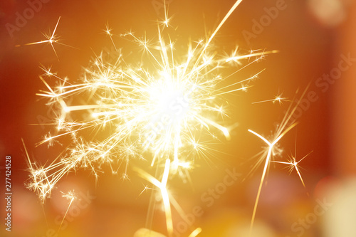 Sparks from hand cold fireworks bright sunspot background