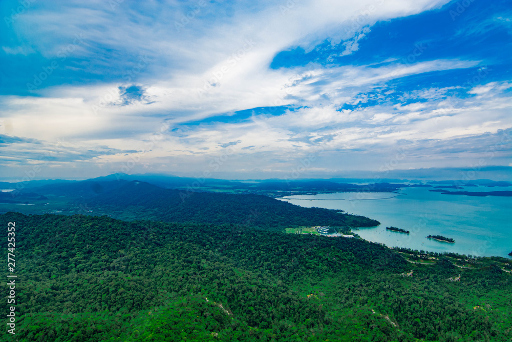 Aerial view of Langkawi island's forest and coastal area with blue sky background Aerial view of Langkawi island's forest and coastal area with blue sky background
