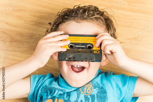 Child looking through the holes of a cassette tape