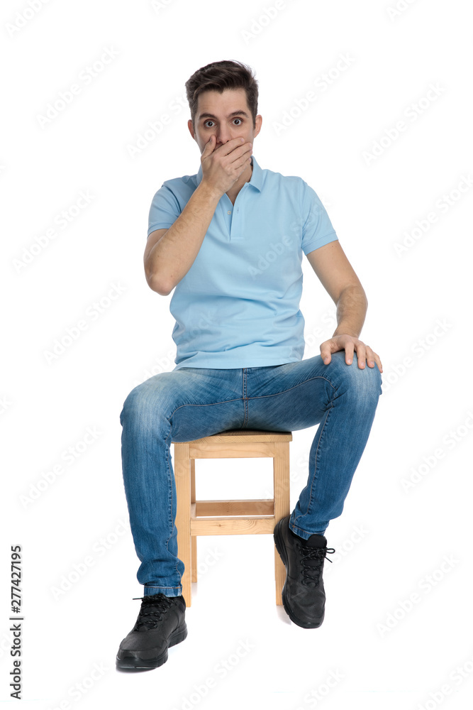 Shocked casual guy covering his mouth with his hand Shocked casual guy covering his mouth with his hand