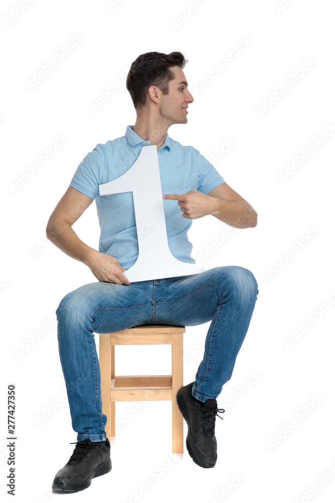 Happy casual guy pointing to his number one Happy casual guy pointing to his number one