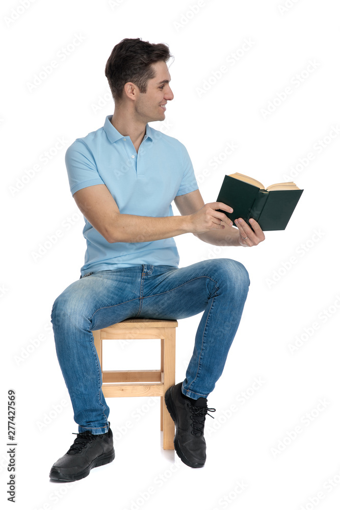 Positive casual man preseting a book to the side