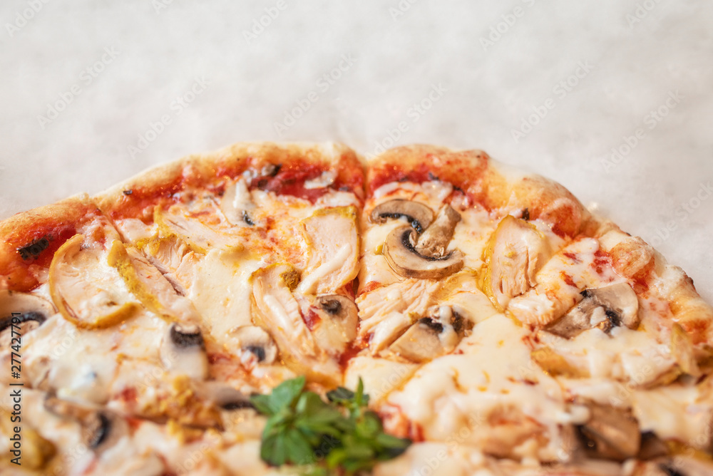 Pizza with chicken and mushrooms close-up on a light background at the bottom of the frame Pizza with chicken and mushrooms close-up on a light background at the bottom of the frame