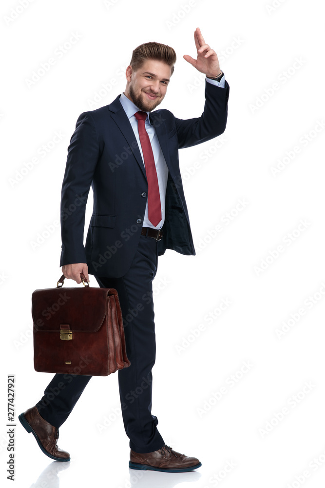 Young businessman holding his briefcase and greeting Young businessman holding his briefcase and greeting