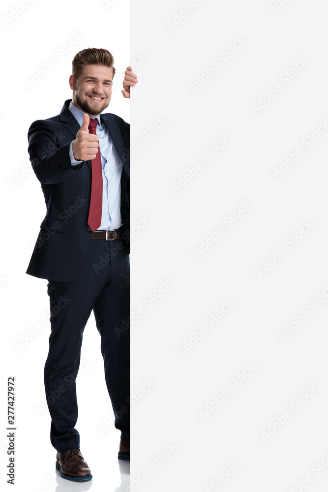 Handsome businessman gesturing ok beside a blank billboard Handsome businessman gesturing ok beside a blank billboard