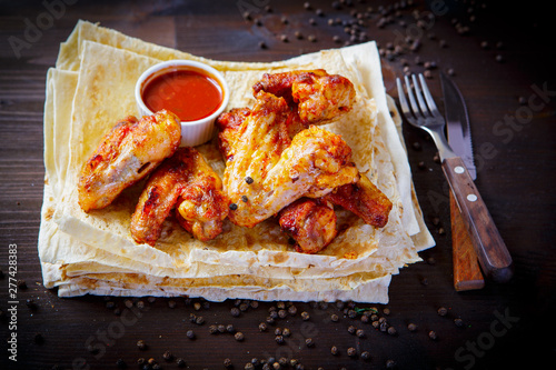 Chicken wings and sauce. Grill dishes for the restaurant menu. Wooden background