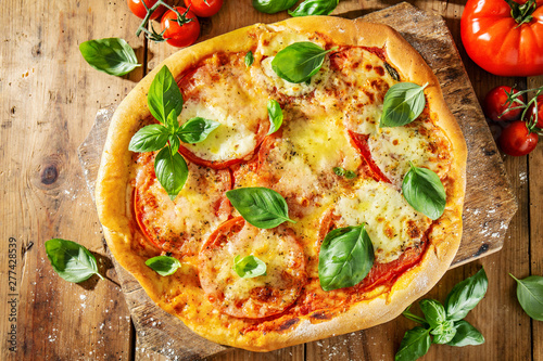 Homemade pizza with mozzarella on wooden background