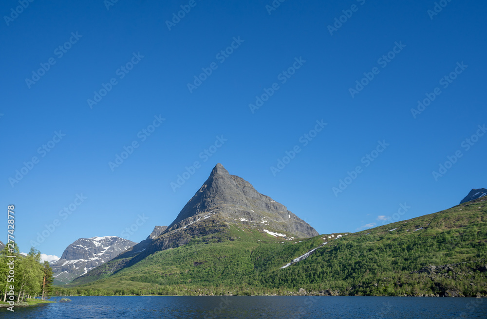 Panoramic view over the lake at Innerdalstarnet (also called Dalatarnet) peak - a 1,452-metre (4,764 ft) sharp pyramidical mountain in the Sunndalen valley. It is called Norwegian Matternhorn. Norway.