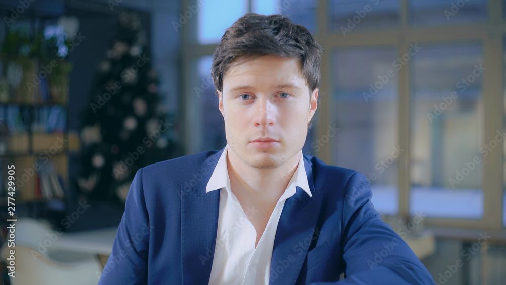 Portrait caucasian fashionable businessman looking at the camera sitting in the office. Adult male wearing in casual blue jacket. Portrait caucasian fashionable businessman looking at the camera sitting in the office. Adult male wearing in casual blue jacket.