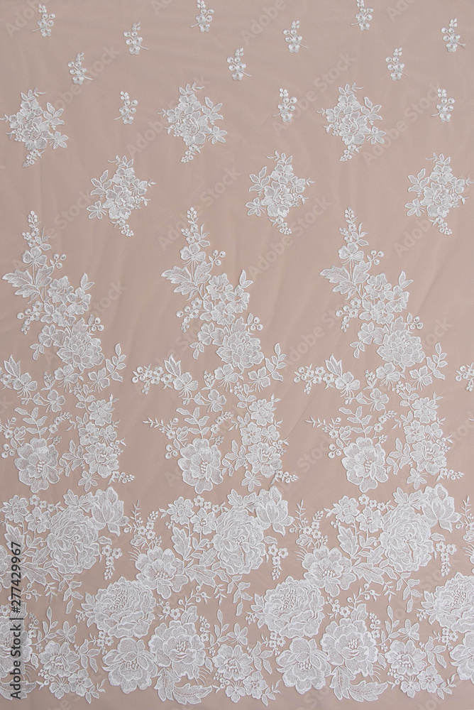 a background image of ivory-colored lace cloth. White lace on beige background.