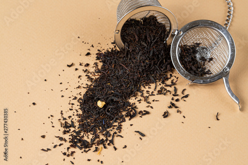 english tea with tea strainer on beige background