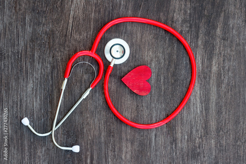 Stethoscope and red heart on wooden background. Health care concept photo