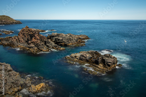 Crystal clear pristine blue water surrounded by a rugged rocky coastline. Elliston, Newfoundland Canada. 