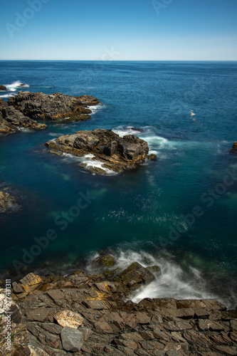 Crystal clear pristine blue water surrounded by a rugged rocky coastline. Elliston, Newfoundland Canada. 