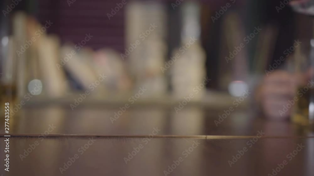 Glass of light beer slowly sliding on the table and falling into the hand of a girl close-up. Leisure at the bar. Slow motion Glass of light beer slowly sliding on the table and falling into the hand of a girl close-up. Leisure at the bar. Slow motion