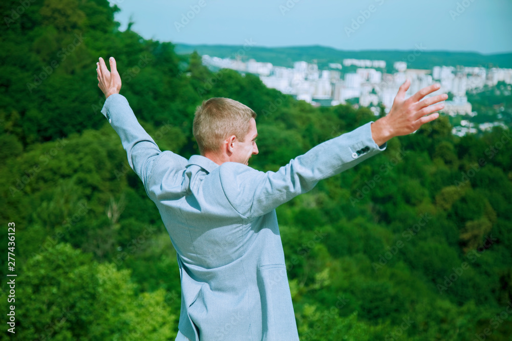Freedom concept. Young successful man looking up with wide open arms Freedom concept. Young successful man looking up with wide open arms