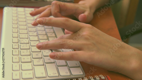 Female hands typing on a white keyboard. Video 4k, UHD.