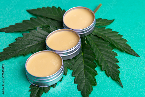 Cannabis salve with hemp and CBD oil on green background