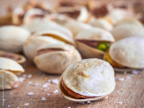 Pistachioes on the wooden and blurry background salty close up