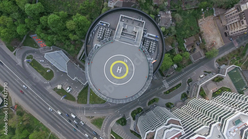 The vertical take-off point from the helicopter pad in the business center, the road, the traffic of cars and the park, the day's shooting from the air are visible below.