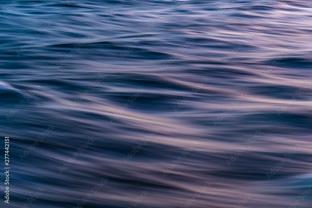Gentle soothing silky flowing natural ocean water movement. Abstract background motion blur. Serene and peaceful deep blue sea in nature. Gentle soothing silky flowing natural ocean water movement. Abstract background motion blur. Serene and peaceful deep blue sea in nature.