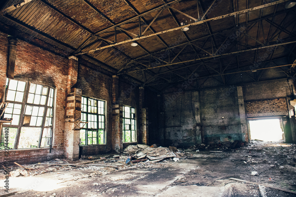 Abandoned ruined industrial warehouse or factory building, corridor view with perspective, ruins and demolition concept