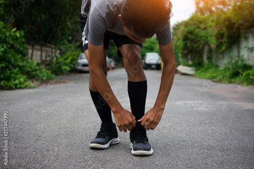 Runners tied in shoes,Man run on the street be running for exercise,Run sports background and closeup at running shoe