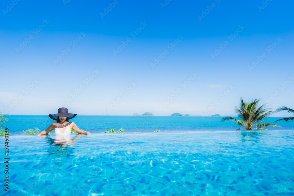 Portrait beautiful young asian woman relax in luxury outdoor swimming pool in hotel resort nearly beach sea ocean