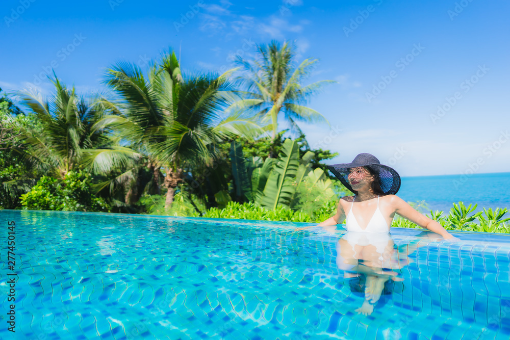 Portrait beautiful young asian woman relax in luxury outdoor swimming pool in hotel resort nearly beach sea ocean Portrait beautiful young asian woman relax in luxury outdoor swimming pool in hotel resort nearly beach sea ocean