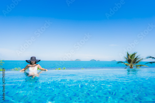Portrait beautiful young asian woman relax in luxury outdoor swimming pool in hotel resort nearly beach sea ocean