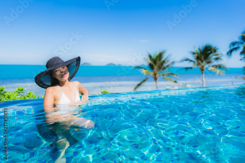 Portrait beautiful young asian woman relax in luxury outdoor swimming pool in hotel resort nearly beach sea ocean © siraphol