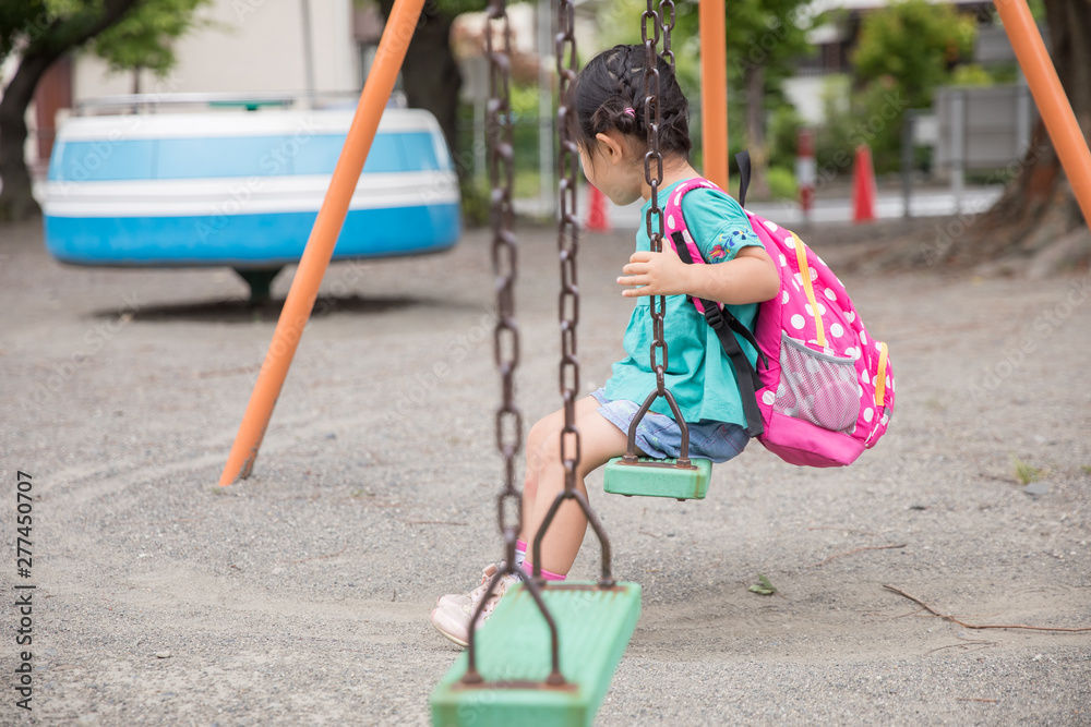 公園のブランコで女の子が一人で寂しそうに俯いている Stock 写真 Adobe Stock
