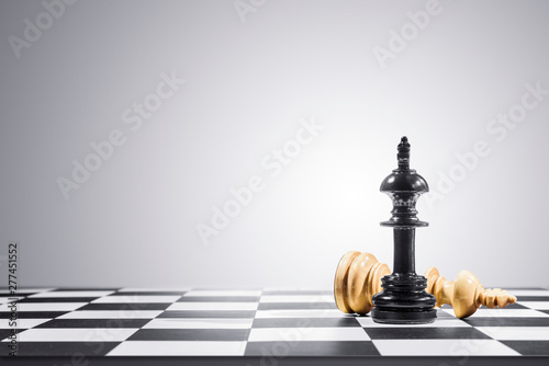 Brown king chess piece defeated by black king chess piece