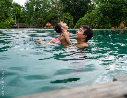 Portrait of Father and daughter enjoying a summer holiday in swimming pool at Northern resort of Thailand.  © scentrio
