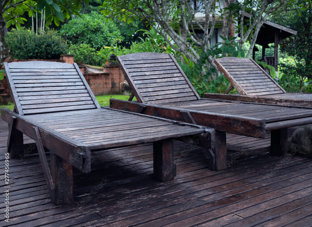Wooden sunbed at the poolside at Northern resort of Thailand in summer day. Wooden sunbed at the poolside at Northern resort of Thailand in summer day.