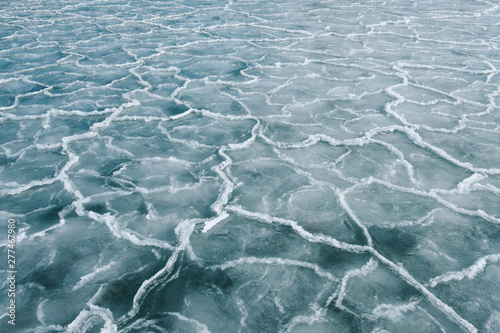 Abstract pattern in the ice of the frozen sea on a freezing cold winter day with clear sky