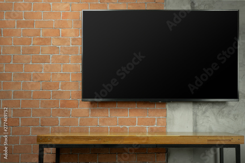 blank screen Led Tv on red brick wall with media wooden table