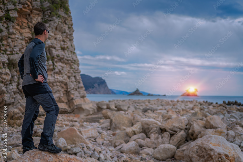 Fototapeta premium Man admiring sunset on the coast in Montenegro