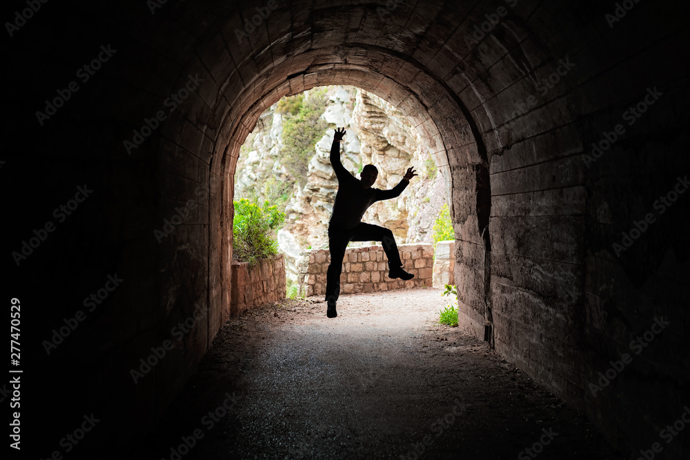 Man jumping in a dark tunnel