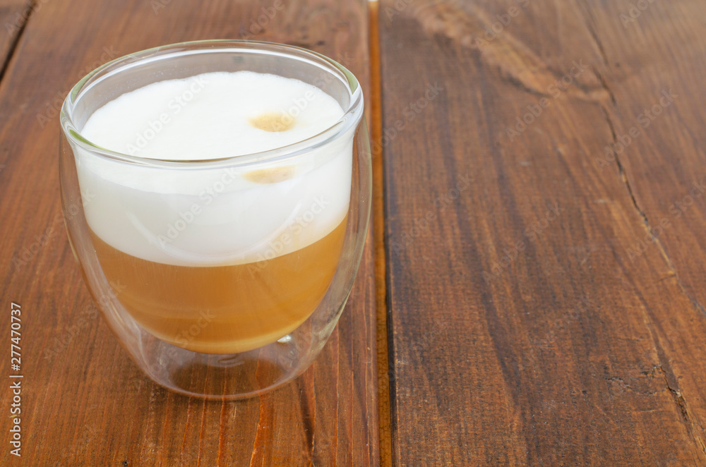 Glass cup with cappuccino on wooden table. Glass cup with cappuccino on wooden table.