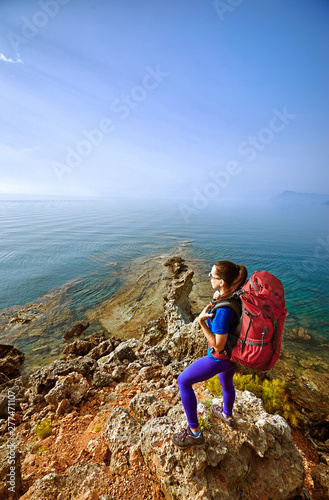 Adventure trek along the coast with a backpack in the summer.