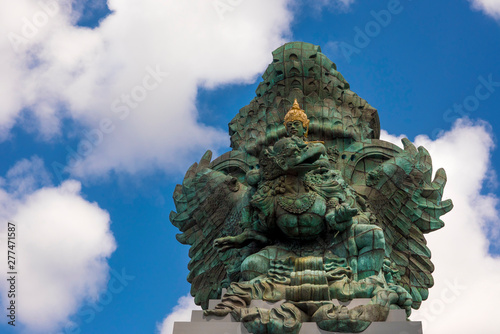 impressive view of Garuda Wisnu green copper statue inspired in Hindu myth standing majestic under a blue sky in Indonesia travel destination landmark