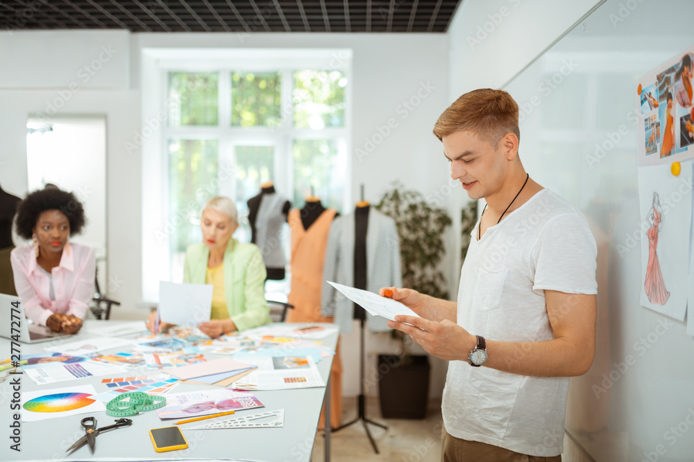 Male fashion designer standing at a cutting table Male fashion designer standing at a cutting table