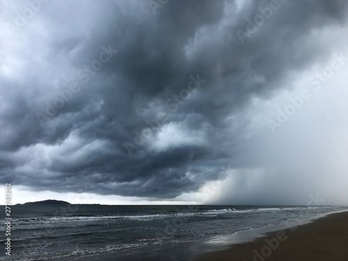 background of dramatic heavy dark clouds over the dark beach