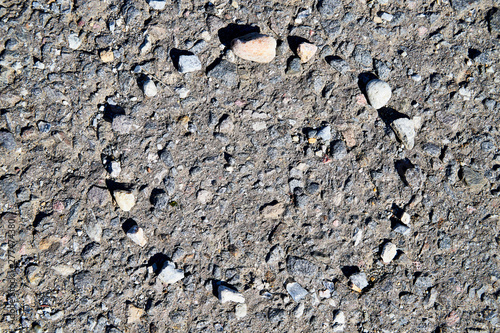 Stone asphalt texture of road and pebbles circle. Grey asphalt road and and a hand-made circle of gravel. Background pebble and gravel photo