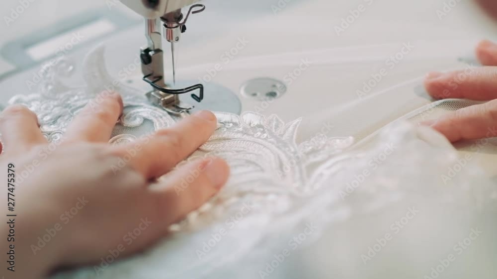 Close up shot of female hands working on sewing machine. woman concept designer working on a sewing machine with lace fabric. Fashion and tailoring.