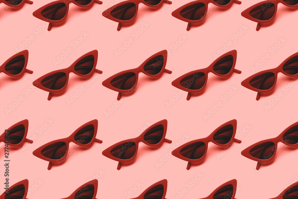 Fototapeta premium Red sunglasses pattern on blue background. Flat lay. Summer concept. From top view.