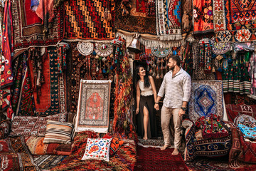 Man and woman in the store. Couple in love in Turkey. Man and woman in the Eastern country. Happy couple travels the world. Persian shop. Tourists in store. Oriental carpet. Istanbul. Follow me