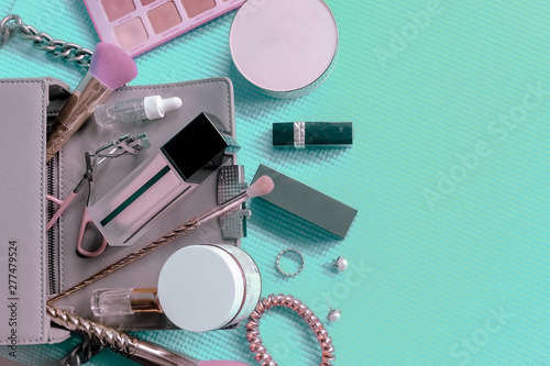 Set of Makeup cosmetics products with bag on green pastel background